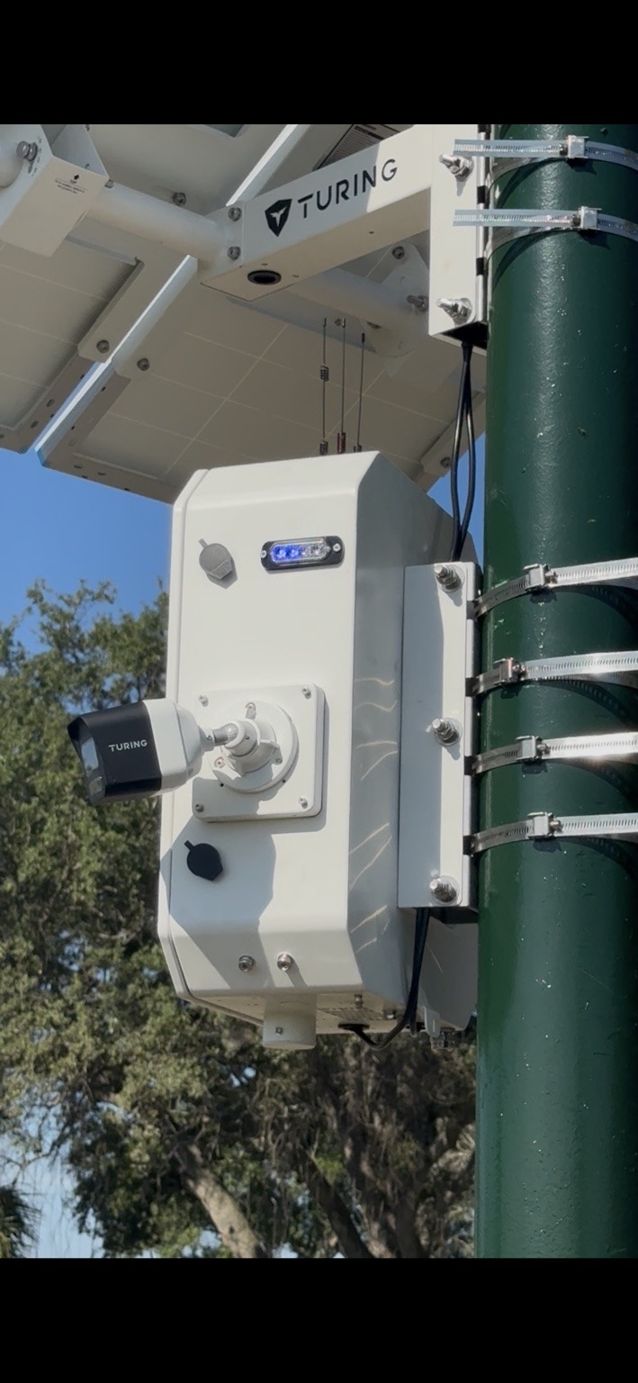 Turing solar-powered surveillance camera mounted on a green pole